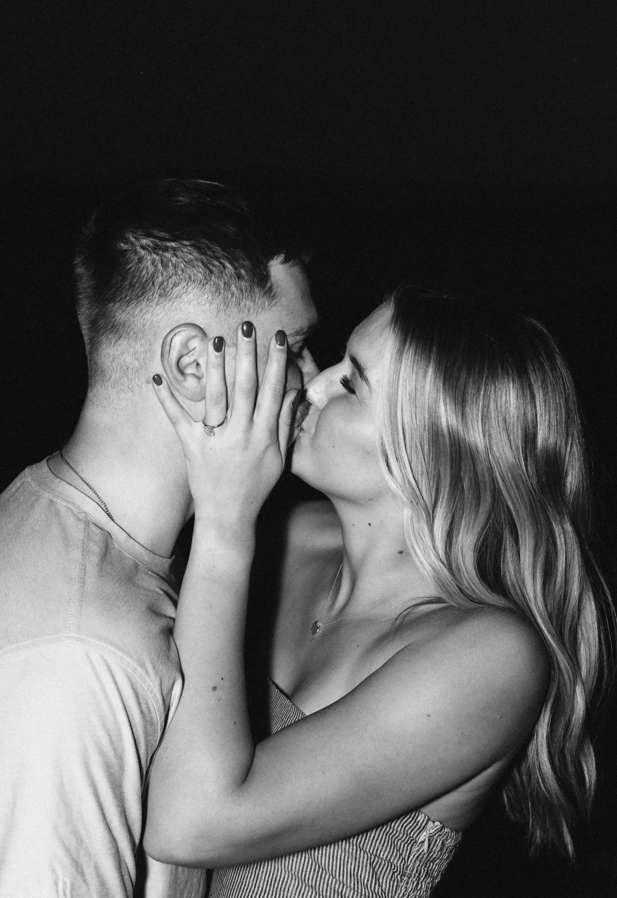 Black-and-white portrait of a couple kissing
