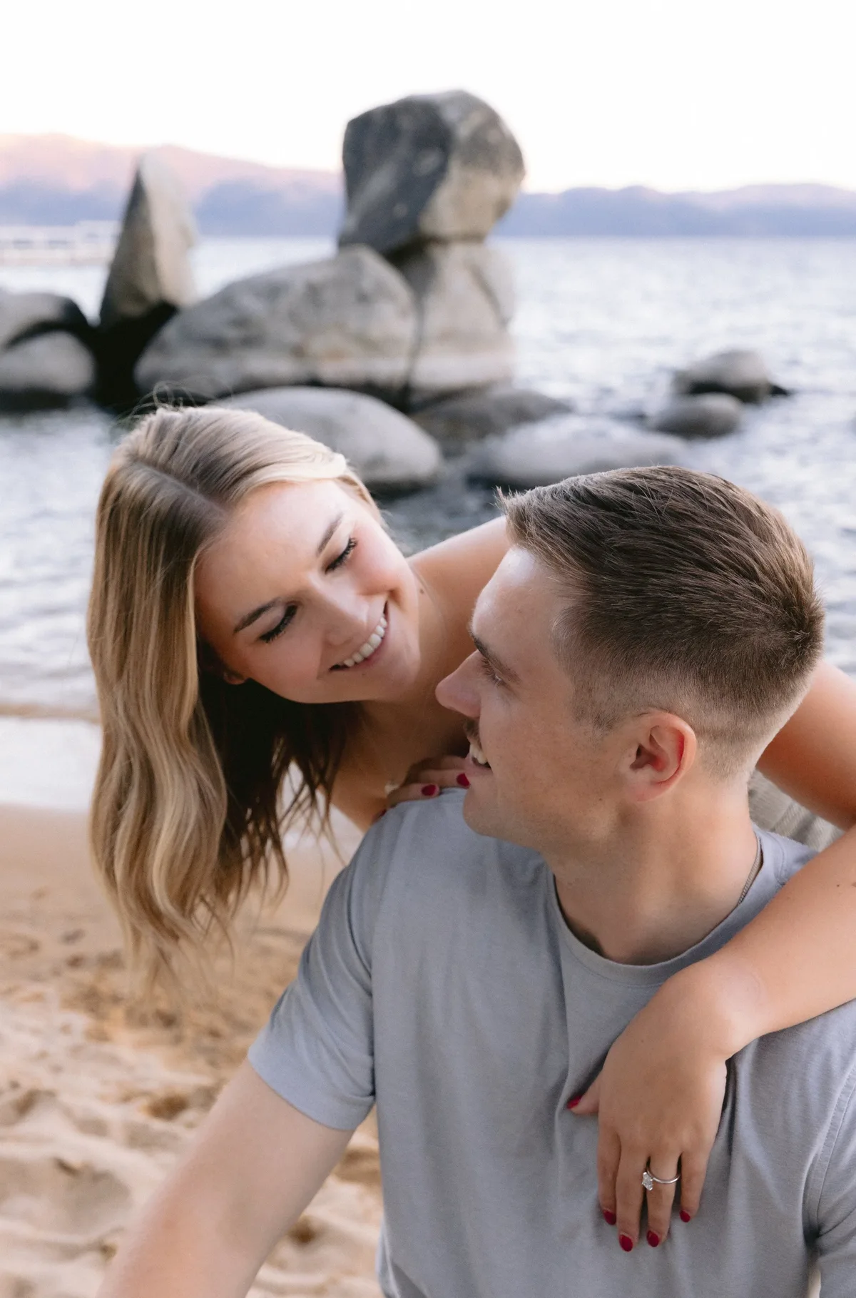 Couple laughing together on a sandy Lake Tahoe beach
