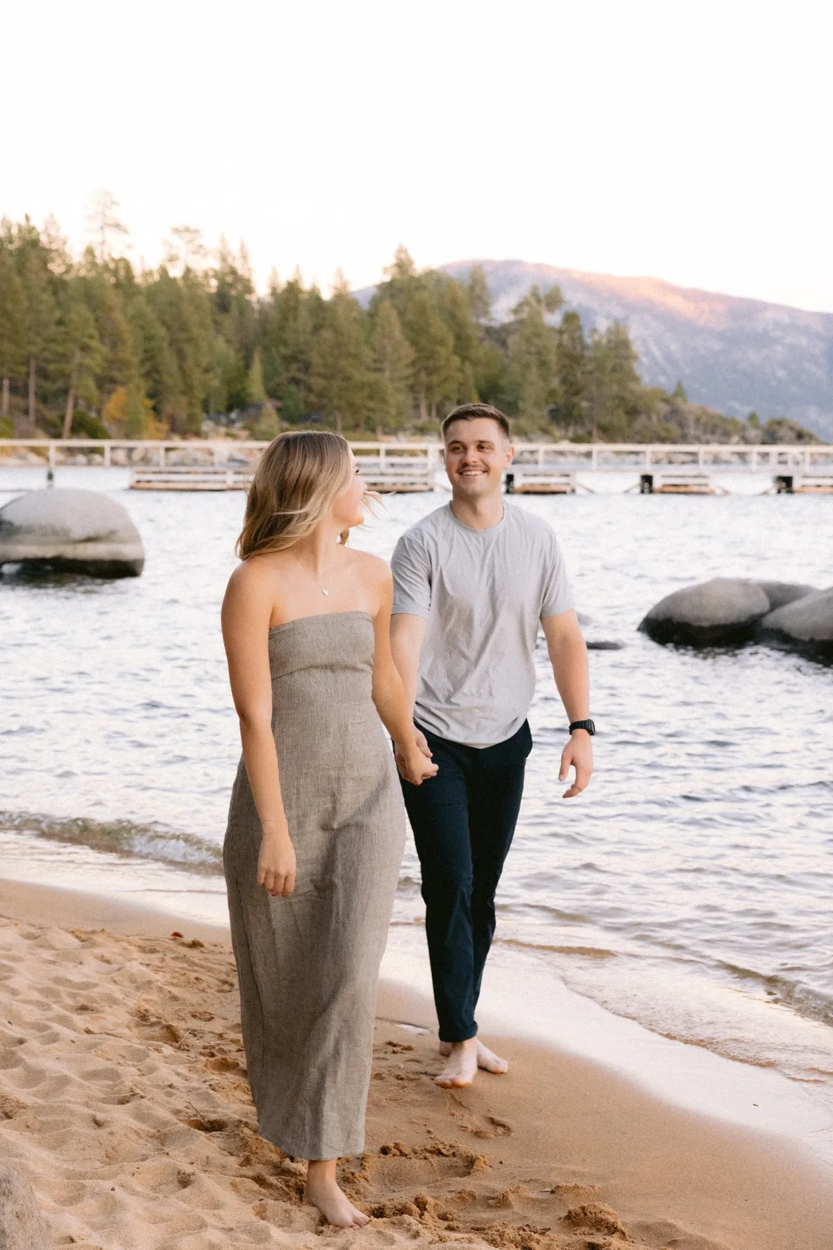 Couple walking hand in hand along the Lake Tahoe shoreline