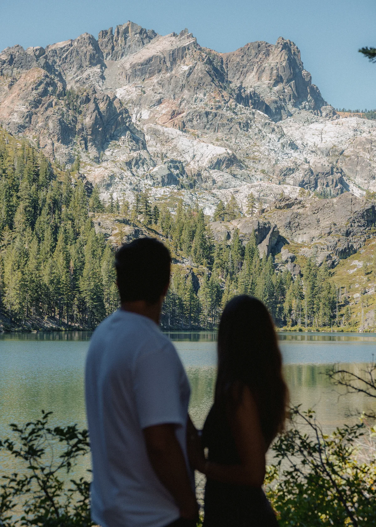 Couple looking across Sardine Lake toward the Sierra Buttes
