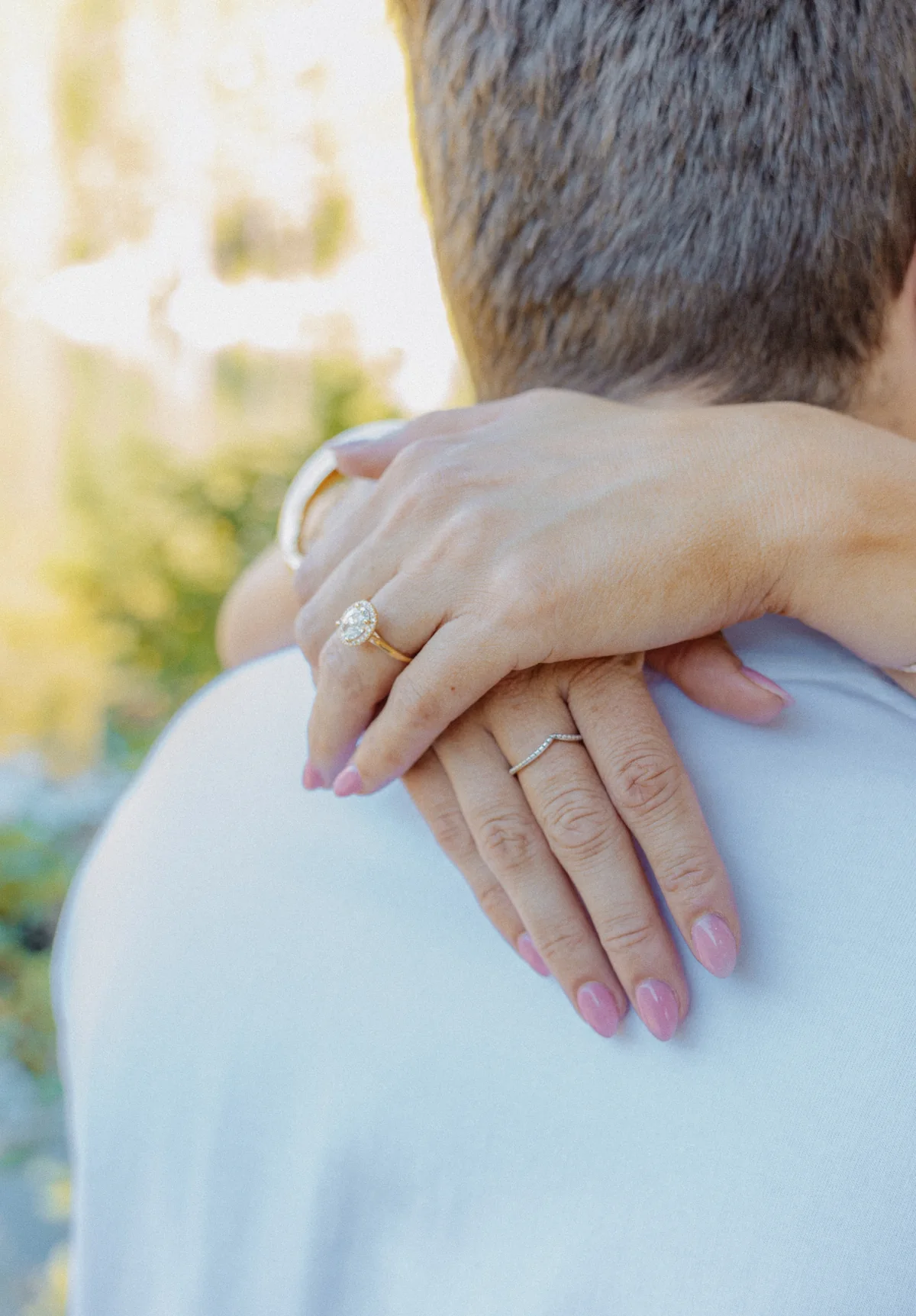 Close detail of an engagement ring on a partner’s shoulder