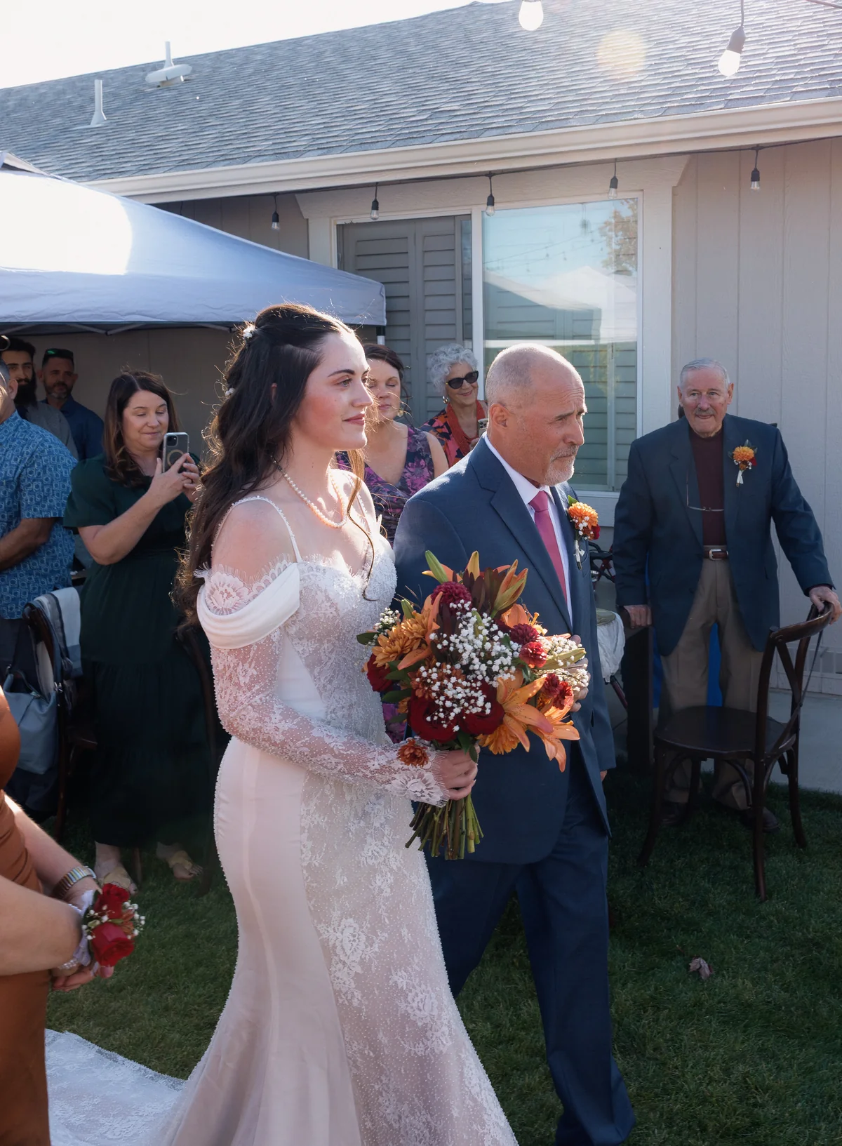 Father walking the bride down the aisle as guests stand