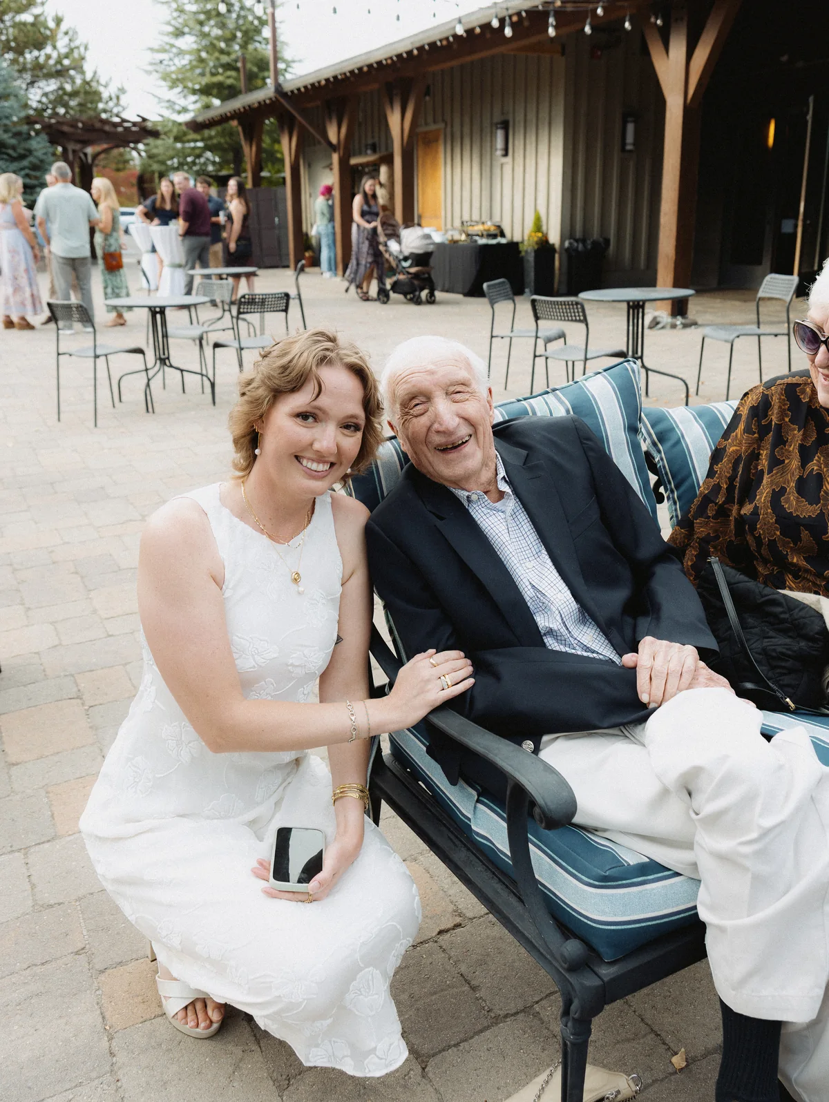 Bride laughing with an older guest seated on the patio
